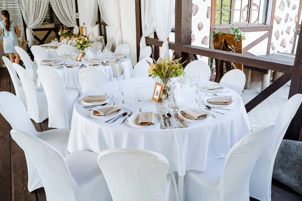 Bayram masası, masaya tabak koymak, beyaz masa örtülü bir ziyafet masası, bayram için yemek masasını hazırlamak, görgü kurallarına göre düzenlenir. Masadaki çiçekler.