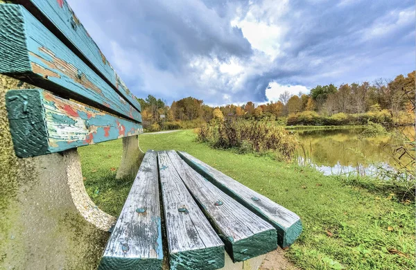 A wooden bench near a lake, an abandoned wooden bench near a beautiful lake
