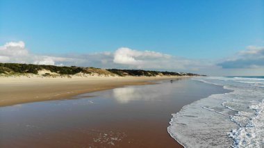 Beyaz kumsalda hava manzaralı dalgalar kopuyor. Deniz dalgaları güzel sahil manzaralı insansız hava aracı görüntülerinde 4k