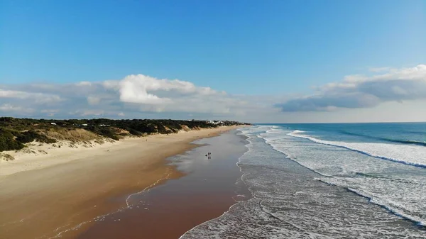 Beyaz kumsalda hava manzaralı dalgalar kopuyor. Deniz dalgaları güzel sahil manzaralı insansız hava aracı görüntülerinde 4k