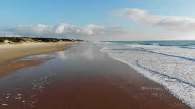 Tropik plaj hava manzarası, tropik beyaz kumsalda dalgaların üst görüntüsü. Deniz dalgaları güzel kumsalda kusursuz bir döngü oluşturuyor.