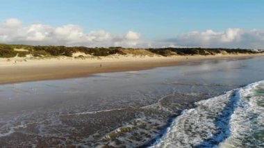 Sunny Beach, geniş açılı dalgaların görüntüsü güzel kumsalda hafifçe sıçrıyor, güneşli bir gün.