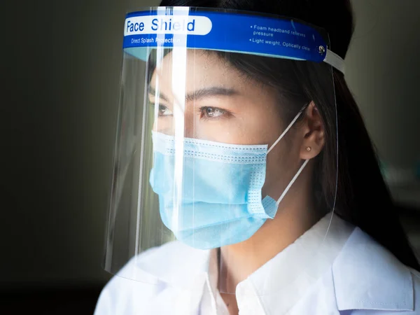 Closeup asian female doctor wears face shield and mask to protect herself from coronavirus or covid-19 spreading. Pandemic outbreak infectious concept.