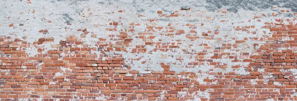 Eğri büğrü, eski tuğla bir duvarın panoraması, kısmen alçılı.