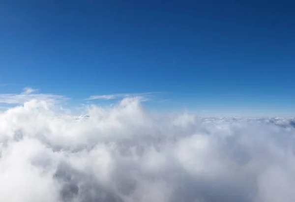 Bulutun üzerinde yükselen bulutlar mavi gökyüzüyle kaplanmıştır