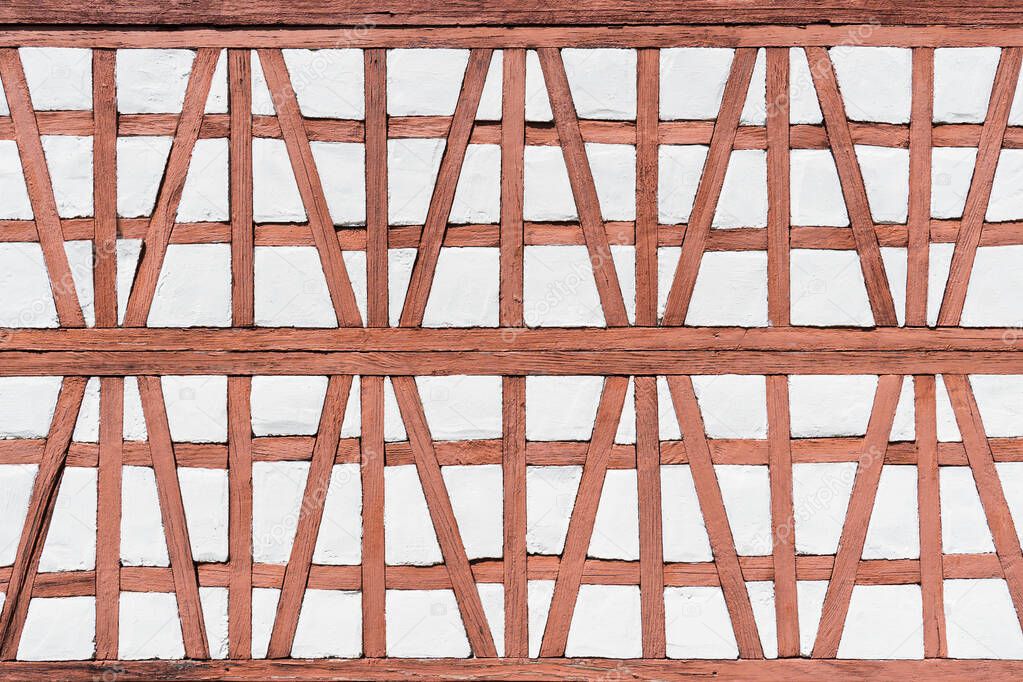 Detail of a half-timbered facade of an old model building house in reddish light brown with white 