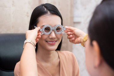 Doktorda vizyon testinden sonra gözlüklü bir kadın.