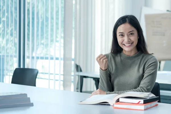 Öğrenciler sınıfta kitap okurlar. Üniversitede üniformalı Asyalı bir öğrenci kitap okuyor.