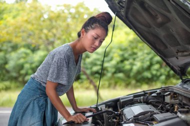 Asyalı kadınlar tatilde rahatça seyahat ederler. Sokakta kırık bir araba.