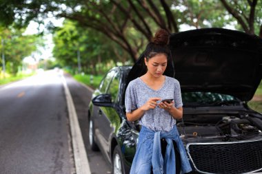 Asian woman using mobile phone while looking and Stressed man sitting after a car breakdown on stree clipart