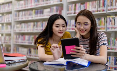 Kütüphanede üniversite öğrencileri. Kütüphanelerde araştırma yapan üniversite öğrencisi grubu.