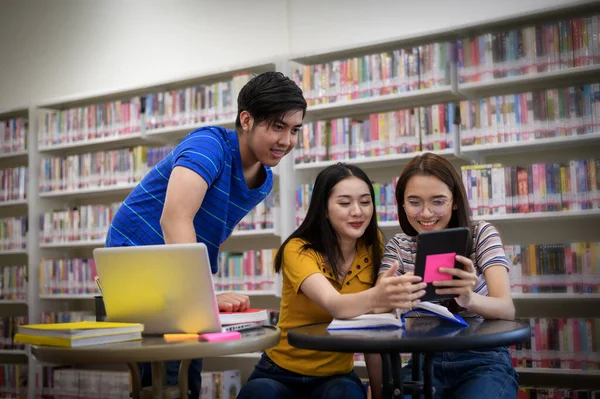 University students in the library.Asian university student group researches in libraries