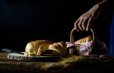Erkek eller tahtanın üzerinde buğday ekmeği kesiyor. Geleneksel ekmek dilimlere bölünür