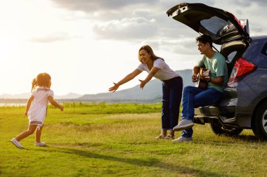 Ailesi arabada oturan mutlu küçük kız. Araba sigortası konsepti.