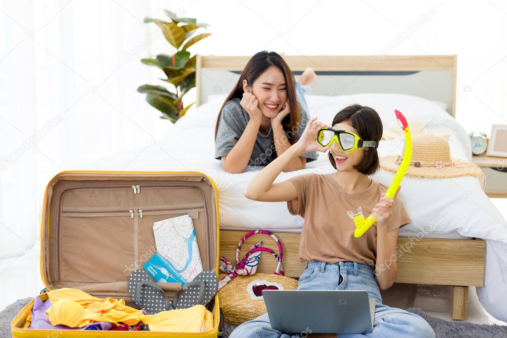 Two young Asian women are preparing to go diving on the weekend. Pretty girls planning a vacation trip in the summer at home.