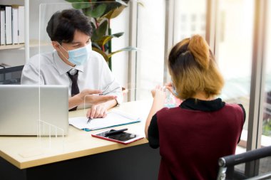 Koronavirüs salgını sırasında (COVID-19) Asyalı erkek çalışanlar, kendisini korumak için düzenli olarak maske takıyor..