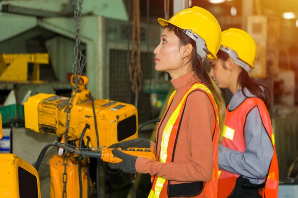 Two Asian women labor, They were wearing safety gear and standing, working in the factory