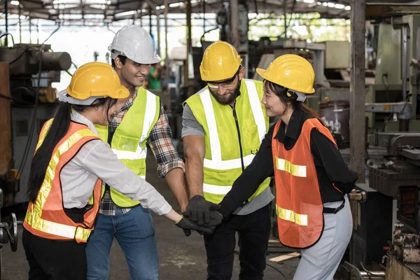 Group of a multi-ethnic factory worker, are standing and showing a happy expression and teamwork in the warehouse.
