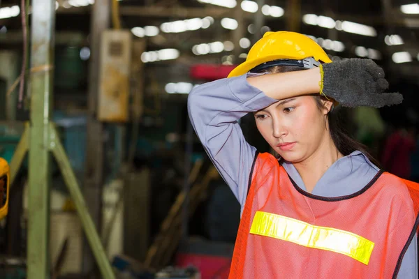 Asian woman labor, She was wearing safety gear and standing, working in the factory