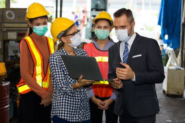 Yakışıklı, sakallı, endüstriyel fabrika sahibi ve kadın mühendis deponun önünde duruyor fabrikayı teftiş etmek için yürüyorlar. Başarılı girişimci konsepti.