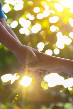 Bir ebeveyn, küçük bir çocuğun elini tutar.