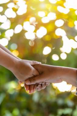 Bir ebeveyn, küçük bir çocuğun elini tutar.