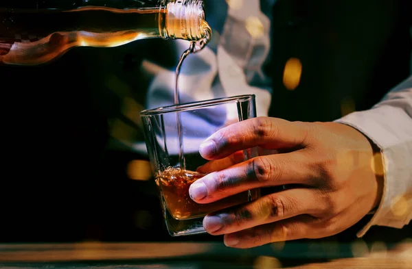 Pouring whiskey drinks on wood