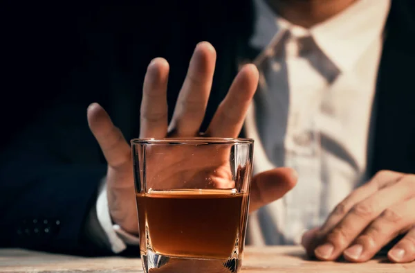 Yakından bir bardak viski tutan iş adamları.