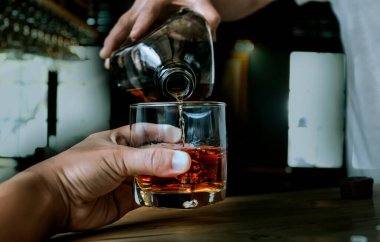 Barmen viski ikram ediyor, ahşap barda.,