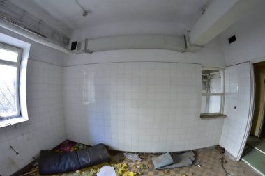 Güneşli bir günde terk edilmiş ve hasar görmüş bir binanın içinde. Enkaz ve harabeler.