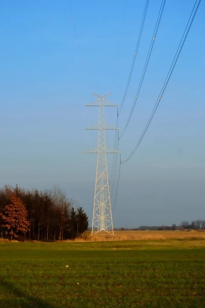 高压电对着天空和农田的塔 — 图库照片