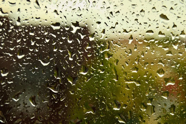 ガラスの上の雨の滴 ぼやけた背景の家で — ストック写真