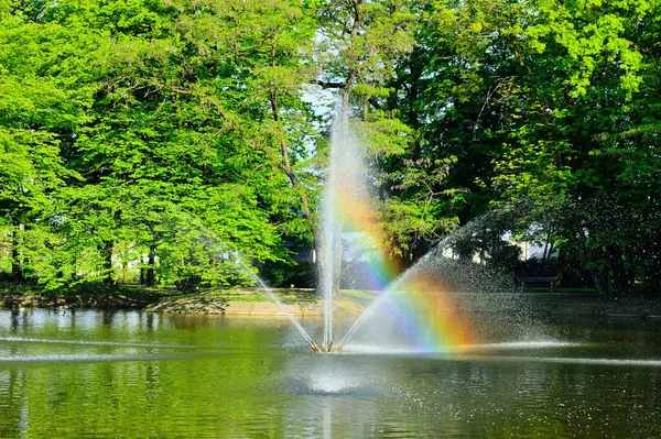 Fontána Tekoucí Vodu Přes Jezero Pozadí Zelených Stromů — Stock fotografie