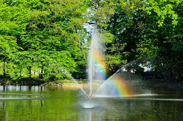 Fontána Tekoucí Vodu Přes Jezero Pozadí Zelených Stromů — Stock fotografie