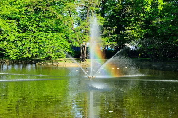 Fontána Tekoucí Vodu Přes Jezero Pozadí Zelených Stromů — Stock fotografie