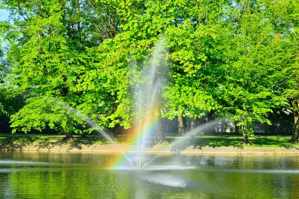 Fontána Tekoucí Vodu Přes Jezero Pozadí Zelených Stromů — Stock fotografie