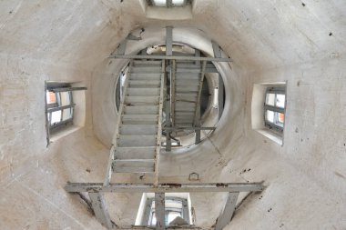 Pencereleri ve merdivenleri olan terk edilmiş ve ihmal edilmiş bir kulenin içi..