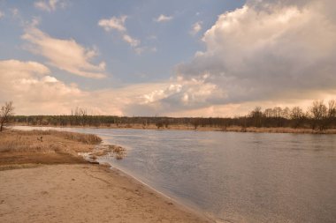 Nehrin diğer tarafındaki ormanın üzerindeki alçak bulutlar. Fırtınalı.