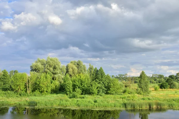 Bulutlu bir günde nehir kıvrılır, gökyüzünde bulutlar. Yaz.