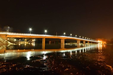 Gece nehir ve nehir kıyısındaki köprü sodyum ve lambalar tarafından aydınlatıldı. Gece.