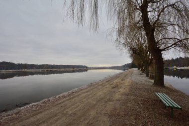Geçit, soğuk bir sonbahar sabahında kasvetli bir sabahta göletin kıyısını nehirden ayırır. Soğuk.