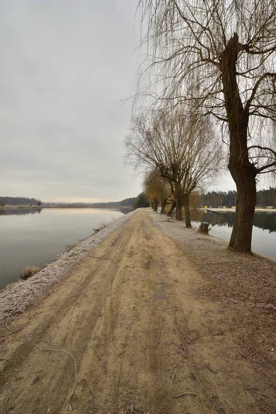 Geçit, soğuk bir sonbahar sabahında kasvetli bir sabahta göletin kıyısını nehirden ayırır. Soğuk.