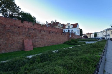 Güneş doğarken Varşova 'nın Eski Kasabası' ndaki Barbican 'ın tarihi savunma duvarları. Yaz.