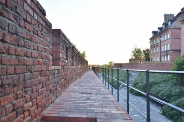 Güneş doğarken Varşova 'nın Eski Kasabası' ndaki Barbican 'ın tarihi savunma duvarları. Yaz.