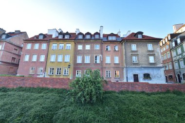 Varşova Barbican 'ının tarihi savunma duvarları ve doğmakta olan güneşin ışığında Eski Şehir' deki Burgher evleri. Yaz.