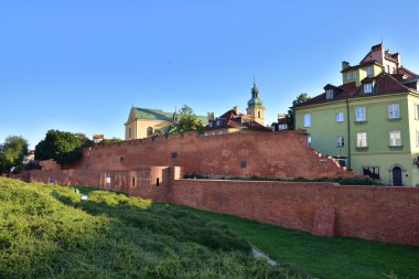 Varşova Barbican 'ının tarihi savunma duvarları ve doğmakta olan güneşin ışığında Eski Şehir' deki Burgher evleri. Yaz.