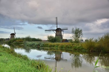 Hollanda 'da bulutlu bir yaz gününde Kinderdijk' te yel değirmenleri. Yaz.