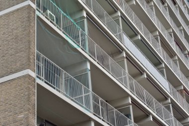 Uzun bir apartman dairesinde balkon ve tuğlalarla dolu bir duvar. Ev.