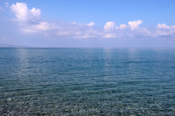 透明的蓝海 云彩映照在水面上 — 图库照片