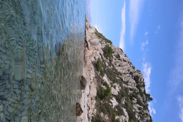 Pittoresk Uitzicht Het Kiezelstrand Baai Transparante Zee Hoge Kliffen Bedekt — Stockfoto